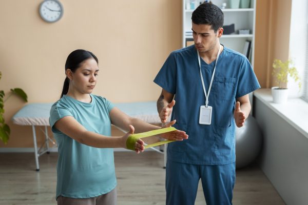 doctor-helping-patient-rehabilitation (1)